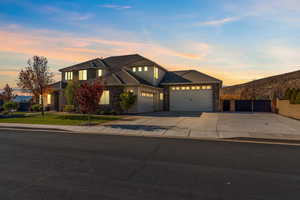 View of front of house featuring driveway, a garage, stone siding, and stucco siding