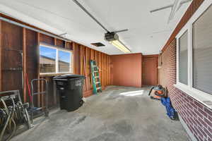 Garage with a garage door opener and wood walls