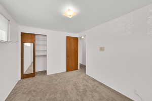 Unfurnished bedroom featuring a closet and carpet floors