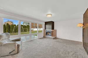 Living room with a fireplace and light colored carpet