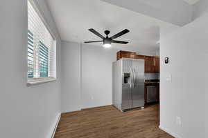 Dining and Kitchen area with brand new appliances with stainless steel finishes, light wood LVP flooring, baseboard heating,  new ceiling fan, and dark cabinetry