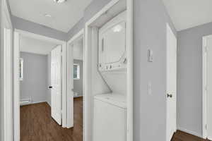 Laundry area with new LVP wood-style flooring, and stacked washer / dryer