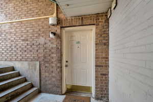 Entrance to property featuring brick siding