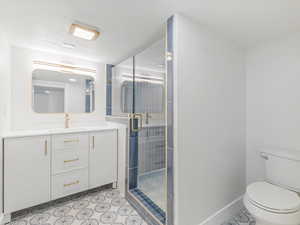 Master Bathroom with vanity, a shower stall, and light tile patterned flooring