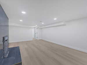 Finished below grade area featuring light wood-style floors and recessed lighting