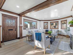 Living room with light wood-type flooring and crown molding