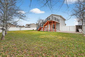 Back of house with a fenced backyard, stairs, a deck, and a patio area