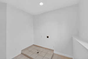 Unfurnished room with baseboards and light tile patterned flooring