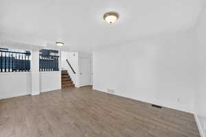 Empty room featuring wood finished floors and stairway