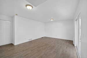 Empty room featuring wood finished floors and a textured ceiling