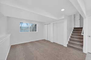Below grade area featuring stairs, carpet floors, and recessed lighting