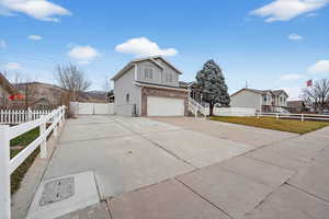 View of front of home with brick siding, driveway, an attached garage, and a mountain view