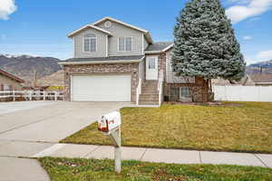 View of front of property featuring a mountain view, brick siding, a garage, driveway, and roof with shingles