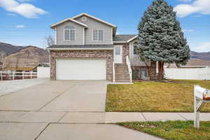 View of front of property featuring brick siding, a mountain view, concrete driveway, an attached garage, and a shingled roof