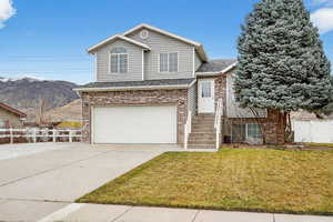 View of front of property with an attached garage, brick siding, driveway, and roof with shingles