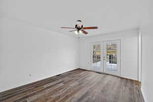 Empty room with french doors, wood finished floors, and ceiling fan