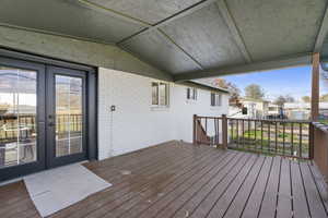 Wooden terrace featuring a residential view, a yard, and french doors