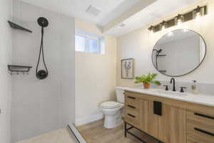 Full bath featuring vanity, walk in shower, and light wood-style floors