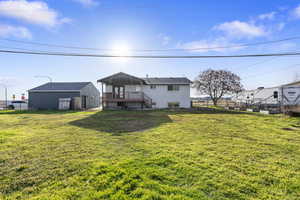 Back of property featuring a wooden deck and an outdoor structure