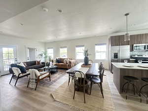 Dining space featuring a textured ceiling, plenty of natural light, light wood-style flooring, and recessed lighting