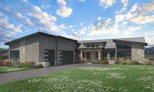 View of front of property with stone siding, a garage, a metal roof, a front lawn, and driveway