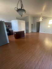 Unfurnished living room with dark wood-style flooring and vaulted ceiling