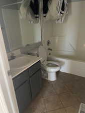 Full bath featuring vanity, shower / bath combination, and light tile patterned floors