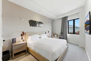 Bedroom with light colored carpet and baseboards