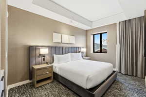 Carpeted bedroom with wallpapered walls and baseboards