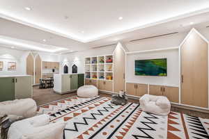 Living room featuring wood finished floors, a raised ceiling, and recessed lighting