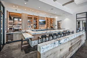 Kitchen featuring a kitchen breakfast bar, recessed lighting, light stone counters, a peninsula, and modern cabinets