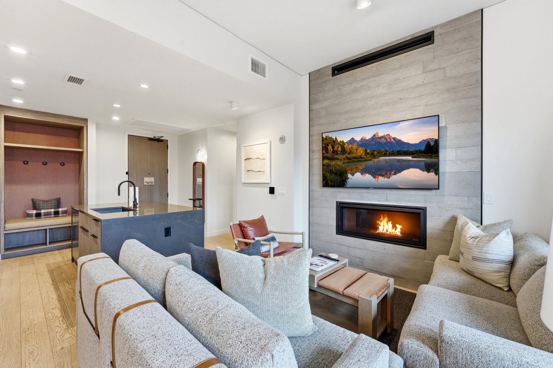 Living room with a fireplace, light wood-type flooring, and recessed lighting