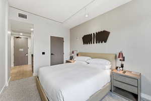 Bedroom featuring light carpet and baseboards