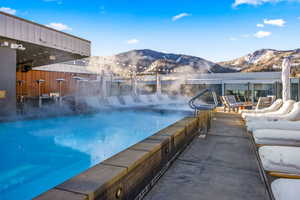 Community pool with a mountain view and a patio area
