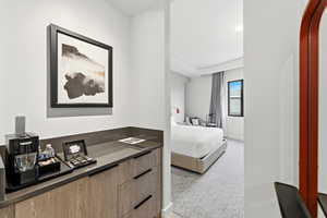 Bedroom featuring light carpet and baseboards