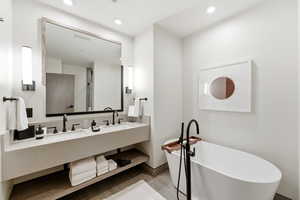 Full bathroom featuring a freestanding bath, double vanity, and recessed lighting