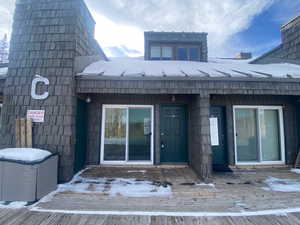 Doorway to property with a chimney and a wooden deck