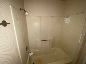 Bathroom featuring  shower combination and wallpapered walls