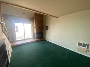 Unfurnished living room featuring carpet and baseboards