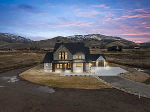 View of front facade featuring a porch, driveway, a mountain view, and stone siding