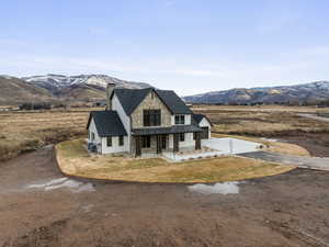 View of front facade with a porch, a mountain view, and driveway