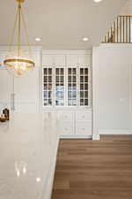 Unfurnished dining area with dark wood-style flooring and recessed lighting