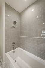 Full bathroom featuring shower / tub combination and baseboards