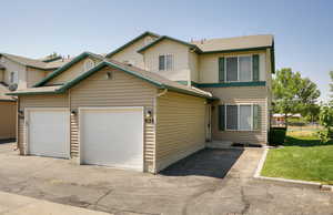 View of front facade featuring roof with shingles, driveway, and an attached garage