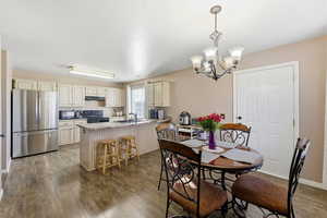 Dining area featuring dark wood-style flooring and a chandelier