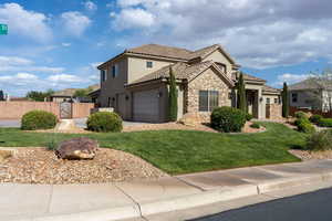 Mediterranean / spanish house featuring stucco siding, stone siding, a tile roof, and a gate