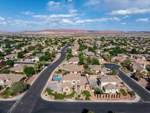 Aerial view of property and surrounding area featuring nearby suburban area and a mountain backdrop