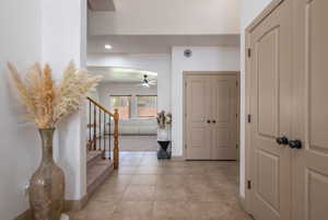 Corridor with light tile patterned floors, recessed lighting, and stairs