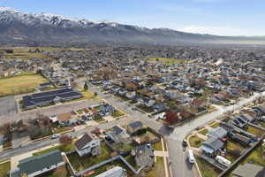 Aerial view of property and surrounding area with nearby suburban area and a mountain backdrop
