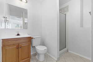 Bathroom featuring a stall shower, vanity, and light tile patterned floors
